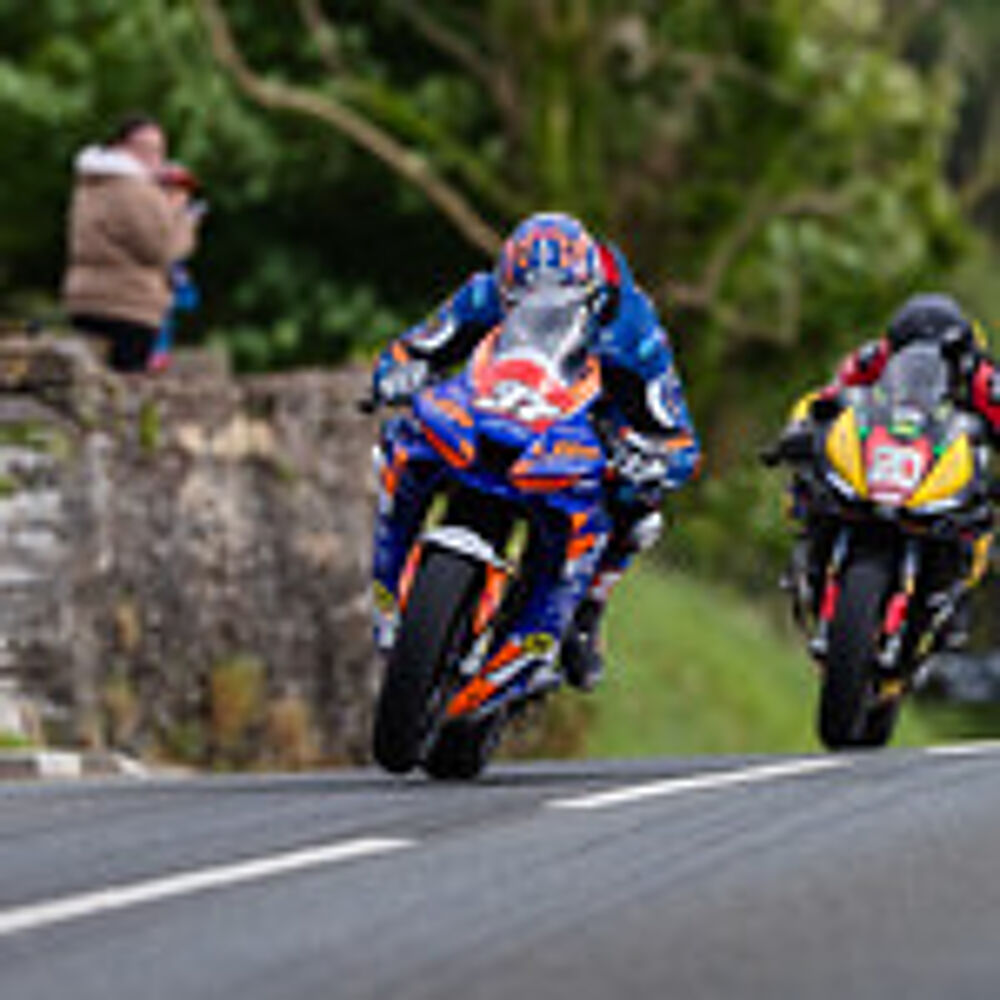 Two motorbikes racing on road.
